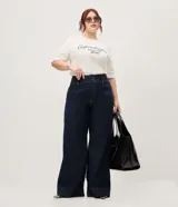 Pantalón de jean wide leg color azul oscuro, confeccionado en algodón resistente, de tiro alto con costuras frontales destacadas en las piernas y diseño de pernera ancha.