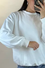 Buzo de cuello redondo, corte oversize, con mangas largas y puños elásticos.