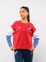 Buzo de cuello redondo con diseño de bloques de color en rojo, blanco y azul. Presenta el logo de Umbro y el escudo del Club Nacional de Football bordados en el pecho.