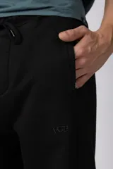 Pantalón de jogging de corte recto y fit relajado, confeccionado en tejido de algodón de color gris azulado. Presenta una caída amplia, cintura elástica y un pequeño logo bordado en la parte superior del muslo.