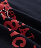 Remera negra de algodón con corte boxy, cuello redondo y mangas cortas. Presenta un estampado frontal en rojo con el texto "MY CHEMICAL ROMANCE" y una araña colgando de una telaraña.