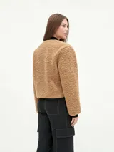 Campera negra de tela tipo sherpa con cierre frontal y cuello redondo.