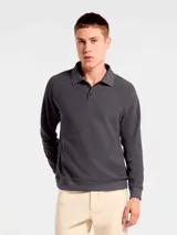 Buzo de manga larga confeccionado en tejido interlock, con cuello tipo polo y cierre frontal de dos botones. Presenta un diseño de corte clásico con puños y ruedo acanalados.