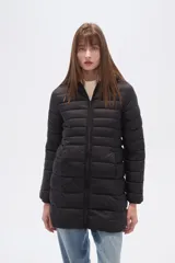 Campera larga acolchada color negro, con cierre frontal y cuello alto. Presenta costuras horizontales que crean un efecto puffer.