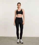 Top deportivo negro de microfibra con efecto satinado, copas removibles y correas dobles ajustables.