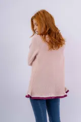 Saco de punto acanalado en color rosado, con cierre frontal mediante lazos tejidos a mano. Presenta mangas largas con puños acampanados y un ruedo evasé, ambos con detalles de franjas en color blanco y bordó.