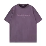 Remera de manga corta color violeta, confeccionada en tela tipo gamuza suave. Presenta un diseño de corte holgado con bordado frontal que incluye las frases 'Health Exercise' y 'PAINS'.