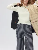 Campera reversible capitoneada con cierre frontal. Un lado es de color negro y el otro es de color beige, ambos con diseño acolchado. Cuenta con cuello redondo, mangas largas y bolsillos laterales.