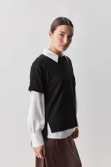 Remera de manga corta negra de algodón, con silueta relajada, cuello redondo y tajos laterales.