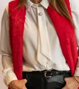 Chaleco largo de piel sintética color blanco, con cuello solapa y dos bolsillos delanteros.