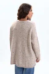 Buzo oversize de tejido de punto en color tostado con efecto jaspeado. Presenta un diseño de corte holgado, cuello redondo y un detalle de costura central vertical (nervio) en el frente.