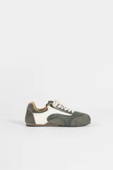 Zapatilla de estilo retro en combinación de colores verde, blanco y gris. Presenta un diseño de paneles superpuestos con texturas lisas y gamuzadas, cordones al tono y suela plana de goma.