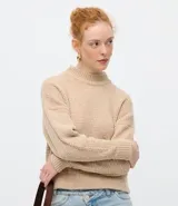 Suéter de punto texturizado con cuello alto, diseño oversized y mangas largas. Presenta una caída amplia y una superficie encorpada, ideal para un estilo moderno y acogedor.