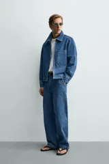 Cazadora de denim de algodón con cierre frontal de cremallera, cuello solapa y un bolsillo plastrón en el pecho. Presenta un diseño de corte regular con efecto lavado.