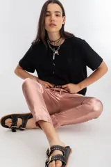 Pantalón de lino metalizado color nude, con cintura alta elástica, corte pitillo, bolsillos laterales y dos bolsillos falsos en la parte trasera.