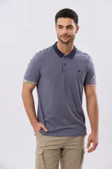 Remera polo de manga corta en color índigo con cuello y botones en contraste. Presenta detalles de color en los puños, aportando un toque sutil y moderno.