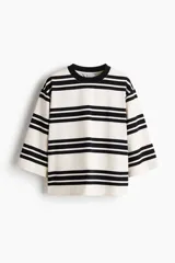 Remera de corte holgado en punto de algodón pesado con diseño a rayas horizontales negras y fondo blanco, cuello redondo acanalado en contraste, hombros caídos y mangas tres cuartos amplias.