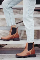 Bota tipo chelsea de cuero color marrón oscuro, con paneles laterales elásticos y suela track robusta con plataforma.