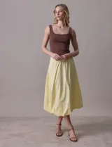 Falda midi color amarillo pálido, de algodón, con pretina ancha elastizada y forro interno a tono.