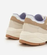 Championes de estilo urbano y deportivo de la marca Satinato, modelo jogging, confeccionados en poliuretano y poliéster en tonos beige, tostado y lila. Presentan una suela robusta texturizada y detalles en malla respirable.