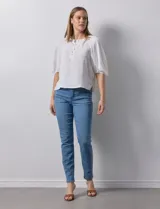 Blusa de gasa blanca con estampado de hojas en azul marino, cuello a la base con escote en V y botones, y mangas cortas abullonadas.