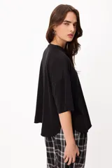 Remera básica de algodón color negro, con cuello redondo y detalle de bordado en el hombro.