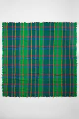 Chal cuadrado con diseño de cuadros en jacquard sobre fondo aguamarina y flecos en los bordes.