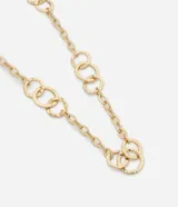 Collar largo de bisutería en tono dorado, compuesto por una cadena de eslabones circulares de diferentes tamaños con acabado texturizado. Incluye cadena de alargue para ajustar el largo.