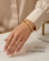 Pulsera tipo esclava rígida de acero con baño de oro, decorada con circonias incrustadas a lo largo de toda la pieza.