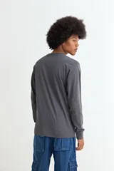 Remera de manga larga, color negro, con cuello redondo y corte recto.