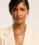 Set de dos collares de metal, uno corto con esferas medianas doradas y otro mediano con esferas pequeñas plateadas.