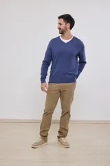 Suéter de punto color azul marino con cuello en V y manga larga. Se lleva sobre una remera blanca con cuello en V.