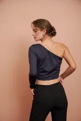 Top corto negro de un hombro con manga larga ajustada.