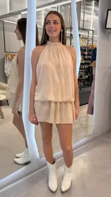Vestido corto beige con brillos de lurex, cuello halter y diseño fluido con silueta holgada.