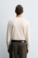 Jersey de punto con mezcla de algodón y cashmere, de corte regular y manga larga. Presenta cuello redondo con cierre frontal de dos botones y acabados en rib.