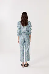 Pantalón de lino metalizado con estampado floral, tiro medio, piernas rectas y bolsillos laterales.