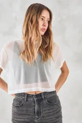 Remera corta de tul blanco, de corte holgado y mangas cortas.