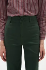 Pantalon tipo jean de corte flare y tiro alto, color verde oscuro, con cierre frontal y bolsillos.