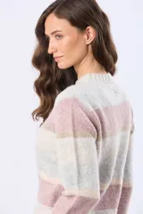 Buzo de tejido de punto con diseño de rayas horizontales en tonos neutros, beige y detalles en rosa y gris. Presenta cuello redondo, mangas largas y terminaciones en rib acanalado en puños y ruedo. Incluye una pequeña etiqueta de cuero sintético en el lateral inferior.