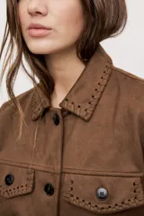 Campera negra de efecto gamuzado con cuello camisero, cierre frontal de botones, bolsillos plaqué en el pecho y detalles de costuras decorativas y calados.