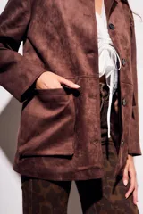 Campera estilo chaqueta marrón oscuro con cuello solapa, cierre frontal con botones oscuros y bolsillos de parche en la parte delantera.