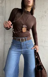 Polera de cuello alto y manga larga, confeccionada en tejido elástico color chocolate.