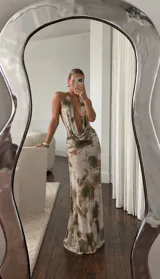 Vestido largo de microtul con estampado tie-dye en tonos beige y verde militar, escote halter pronunciado y espalda descubierta con tiras regulables.