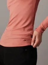 Top entallado de modal elástico con estructura de canalé, cuello Perkins y mangas largas.