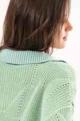 Buzo de punto color verde menta, con cuello polo y escote en V, mangas cortas y diseño holgado.