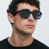 Lentes de sol de diseño cuadrado con montura de acetato en color negro y cristales polarizados en tono celeste.