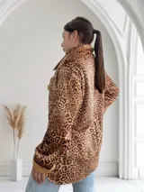 Sobrecamisa de pana color beige con estampado animal print de leopardo, cuello camisero, cierre con botones y puños con detalle de piel sintética.