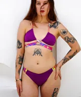 Conjunto de bikini color violeta con tiras finas y estampado multicolor.