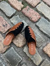 Zapatos chatos color dorado y mostaza con cordones decorativos.