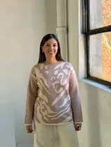 Sweater de tejido de punto con diseño abstracto en tonos beige y crema, de corte holgado, cuello redondo y manga larga.
